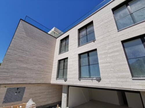 Harmonische Natursteinfassade mit Fensterfront